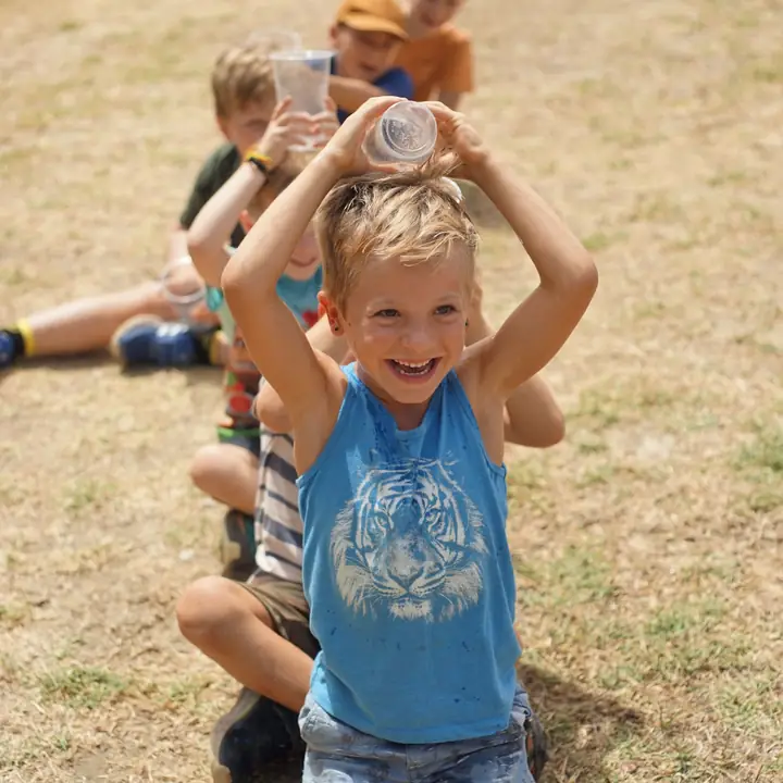 Children playing with cups outside at Alma Forest School